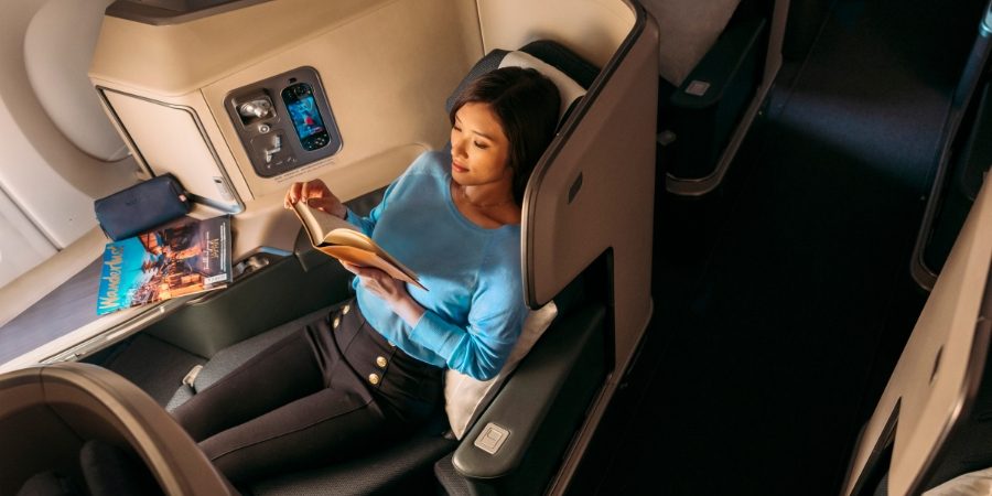 A woman on Business seats sleeps on a fully flat bed 